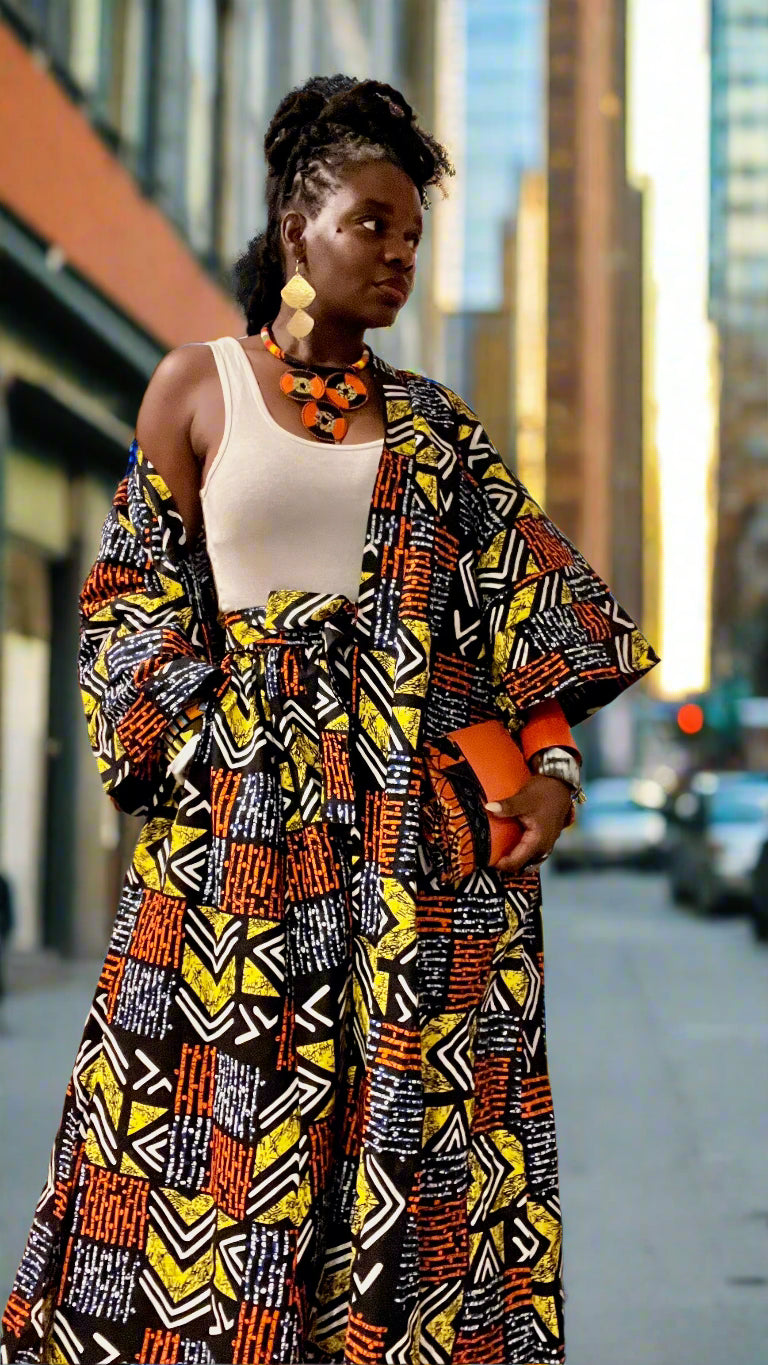 Woman wearing a colorful patterned outfit in a room with art on the walls.